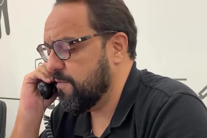Thiago Kuin ao telefone na encenação sobre a venda de higienização de estofados.